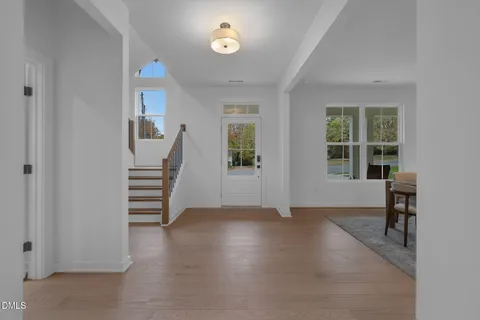 a kitchen with kitchen island granite countertop wooden floors and white cabinets