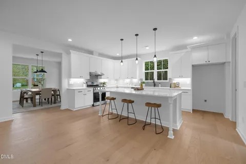 a kitchen with stainless steel appliances kitchen island a white cabinets and couches