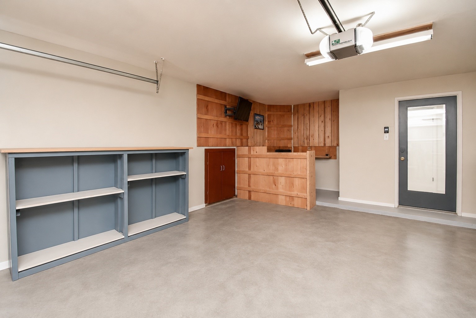 8715 Vinkins Road Houston, TX 77071 - Photo 47 of 48 The attached garage offers more than parking, featuring a built-in workstation, ample shelving, and dedicated workspace—perfect for hobbies, DIY projects, storage, or a home workshop. Virtually decluttered.