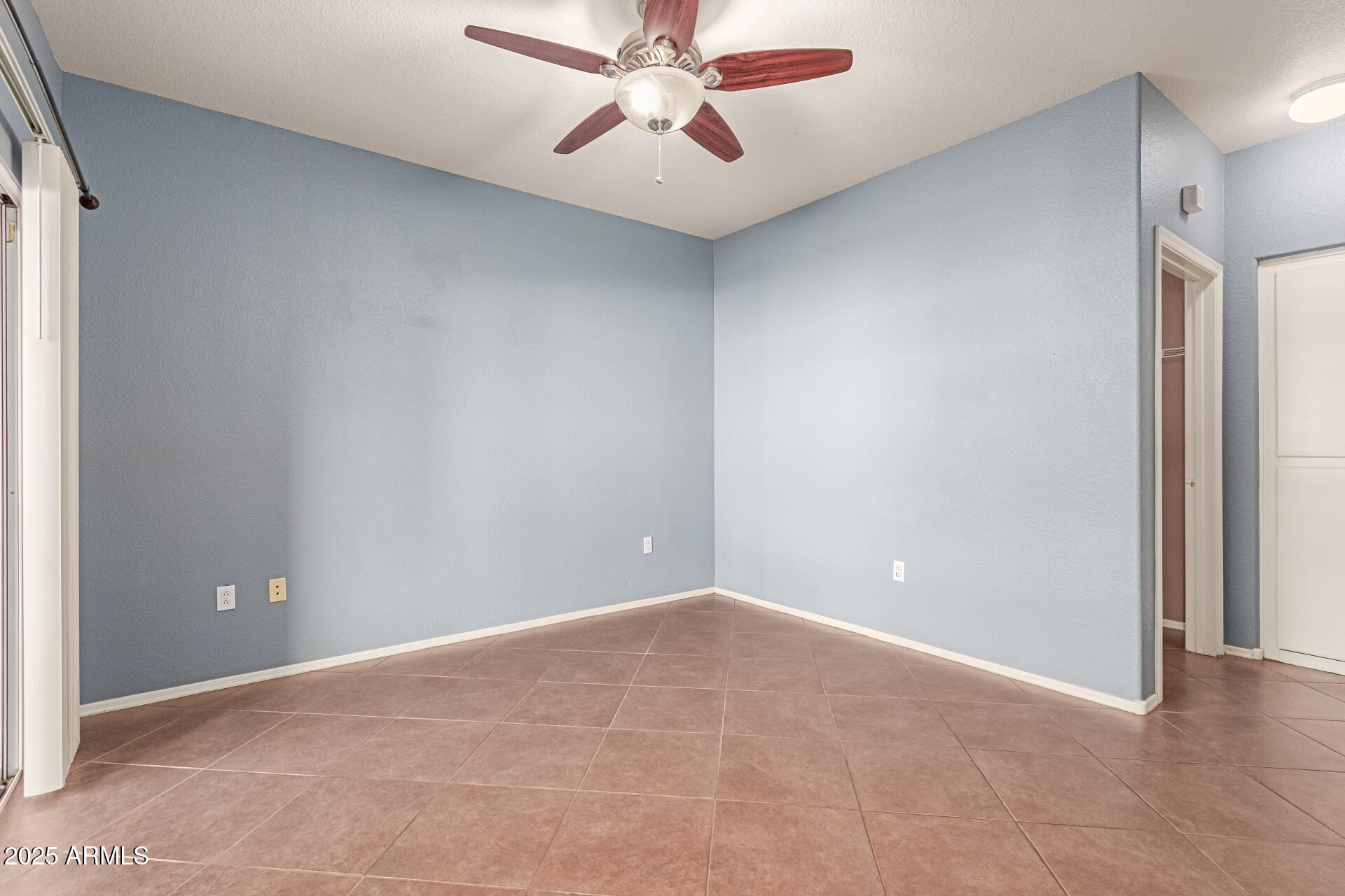 3236 East Chandler Boulevard, Unit 1082 Phoenix, AZ 85048 - Photo 17 of 28 an empty room with chandelier fan and windows