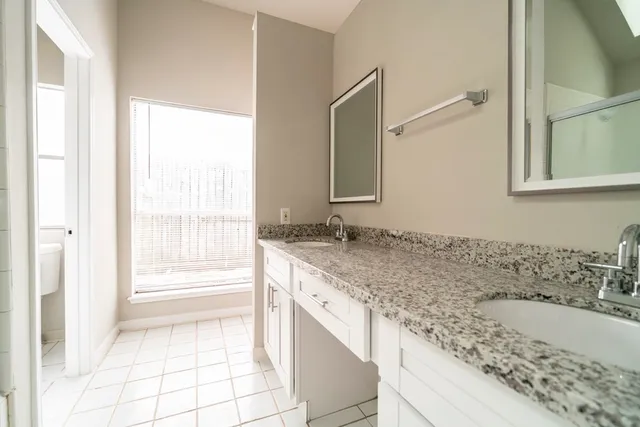 a bathroom with a granite countertop sink and a bathtub