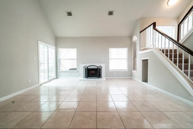 a view of an empty room with a window and fireplace