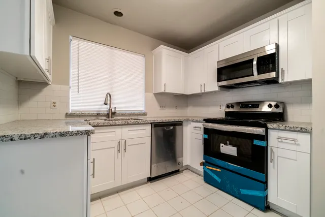 a kitchen with stainless steel appliances granite countertop a sink and a stove