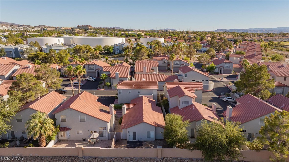 2254 Ramsgate Drive Henderson, NV 89074 - Photo 39 of 43 An aerial perspective reveals a vibrant neighborhood under the clear desert sky, showcasing tiled rooftops and green landscaping.