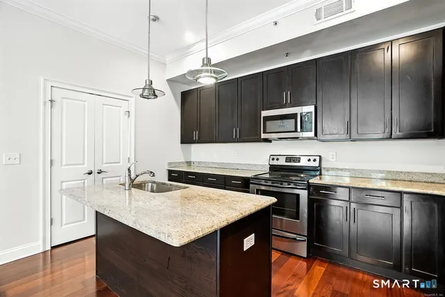 a kitchen with stainless steel appliances granite countertop a sink stove and refrigerator