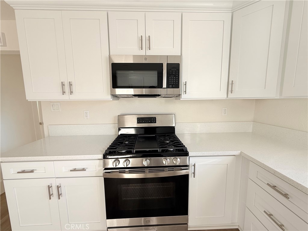 392 West L Street Colton, CA 92324 - Photo 11 of 41 a kitchen with microwave cabinets and stove top oven