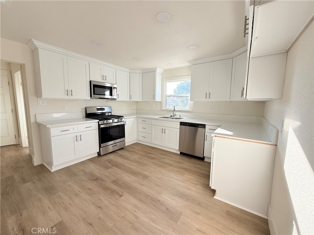 392 West L Street Colton, CA 92324 - Photo 13 of 41 a kitchen with white cabinets and white appliances