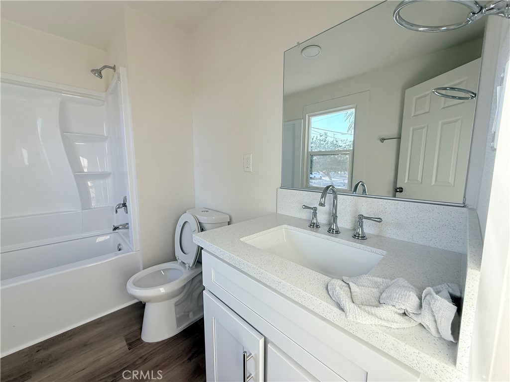 392 West L Street Colton, CA 92324 - Photo 20 of 41 a bathroom with a granite countertop toilet sink and mirror