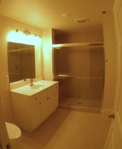 a bathroom with a granite countertop sink a toilet and mirror
