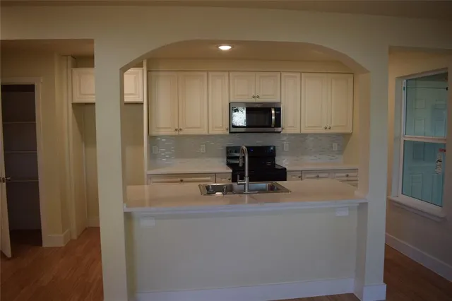 a kitchen with kitchen island a sink appliances and cabinets