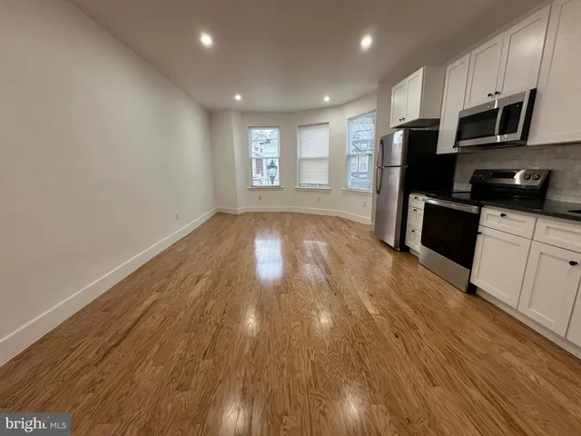 a view of kitchen with sink and refrigerator