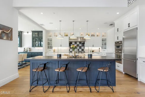 a kitchen with a dining table chairs and white cabinets