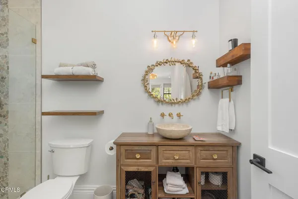 a bathroom with a toilet sink vanity and shower