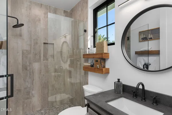 a bathroom with a sink a toilet and shower