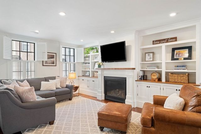 a living room with furniture a fireplace and a flat screen tv