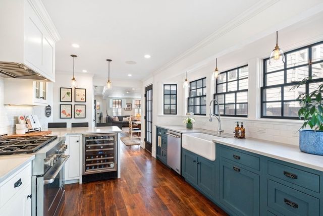 a large kitchen with stainless steel appliances a stove a sink and dishwasher wooden cabinets with wooden floor