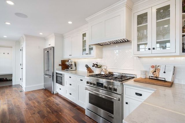 a kitchen with stainless steel appliances granite countertop a stove and a refrigerator