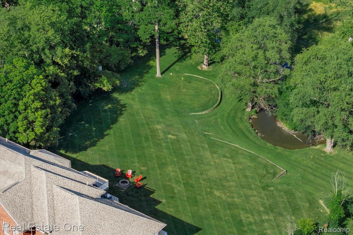 33850 Braebury Ridge Farmington, MI 48331 - Photo 78 of 85 Expansive green lawn with a visible putting green and a natural water feature