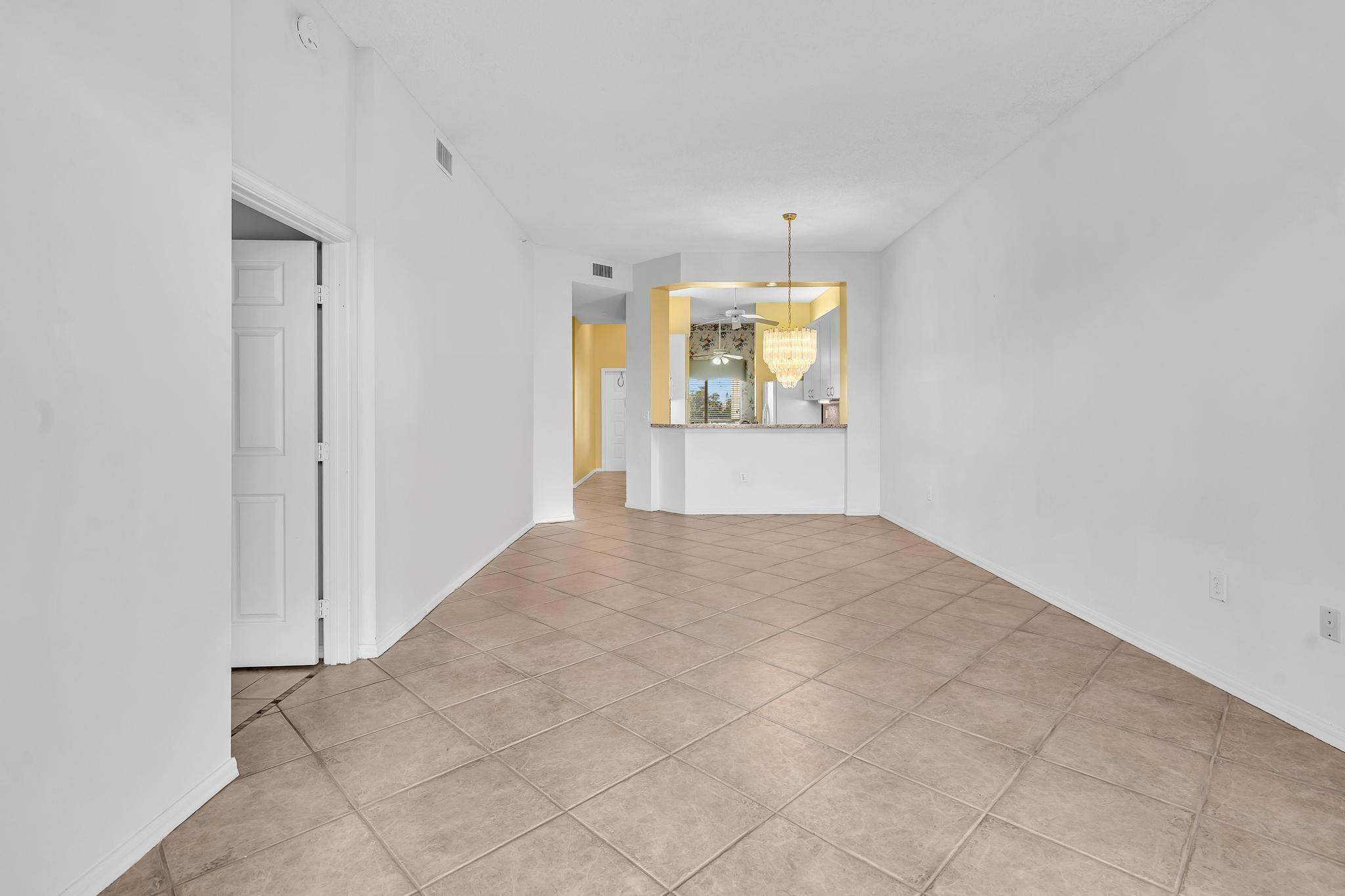 9551 Weldon Circle, Unit E411 Tamarac, FL 33321 - Photo 15 of 78 an empty room with windows and chandelier