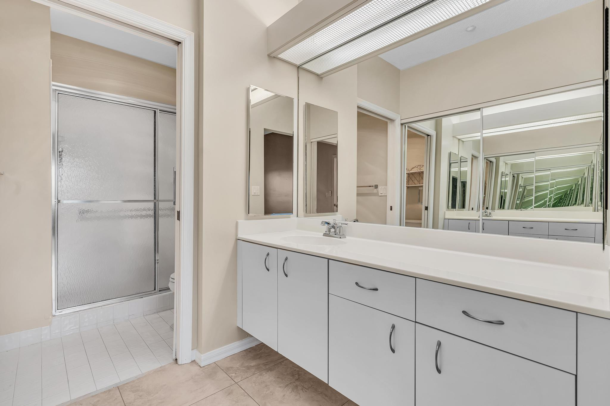 9551 Weldon Circle, Unit E411 Tamarac, FL 33321 - Photo 22 of 78 a bathroom with a shower sink and mirror