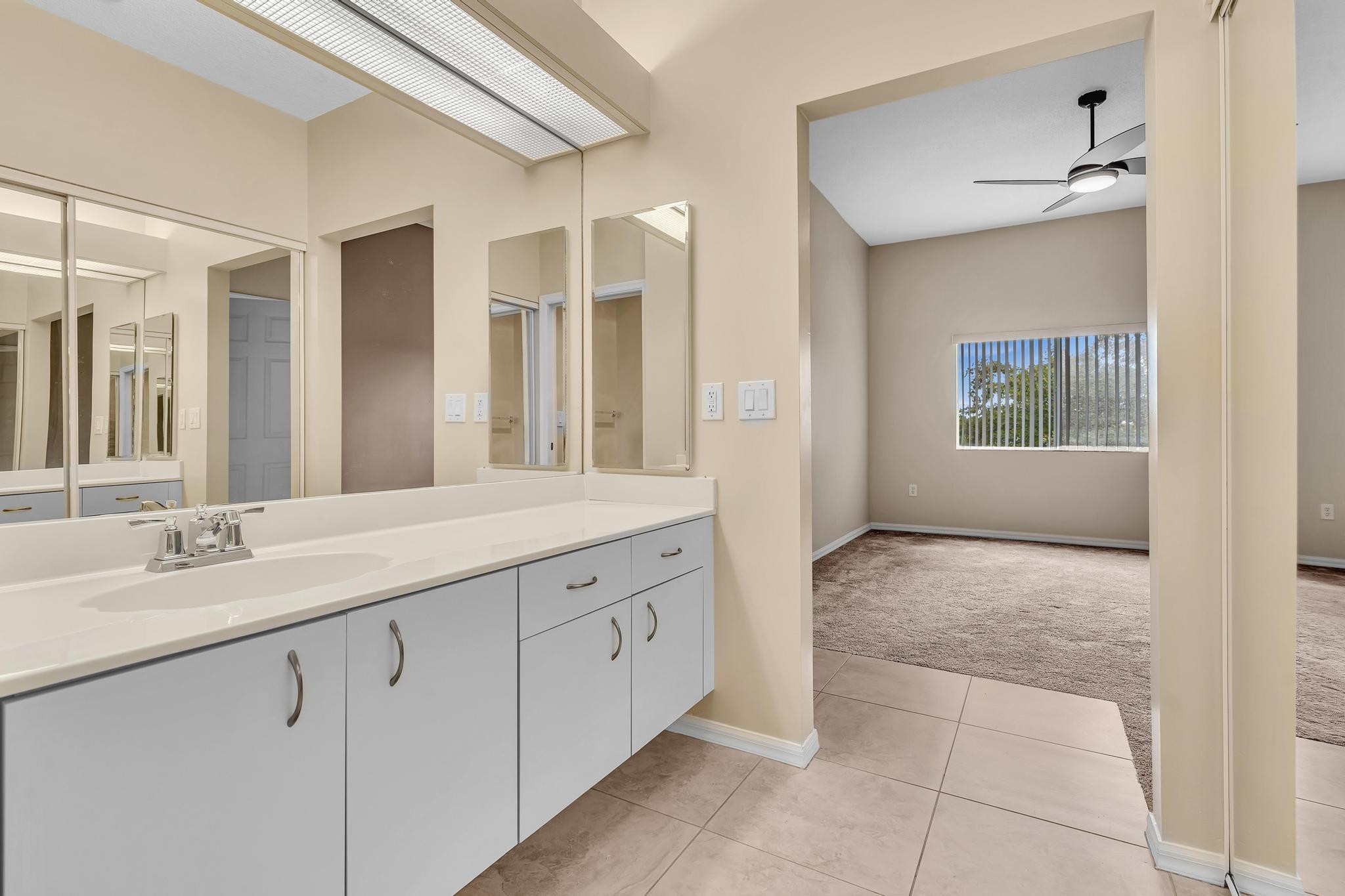 9551 Weldon Circle, Unit E411 Tamarac, FL 33321 - Photo 23 of 78 a spacious bathroom with a granite countertop sink mirror and