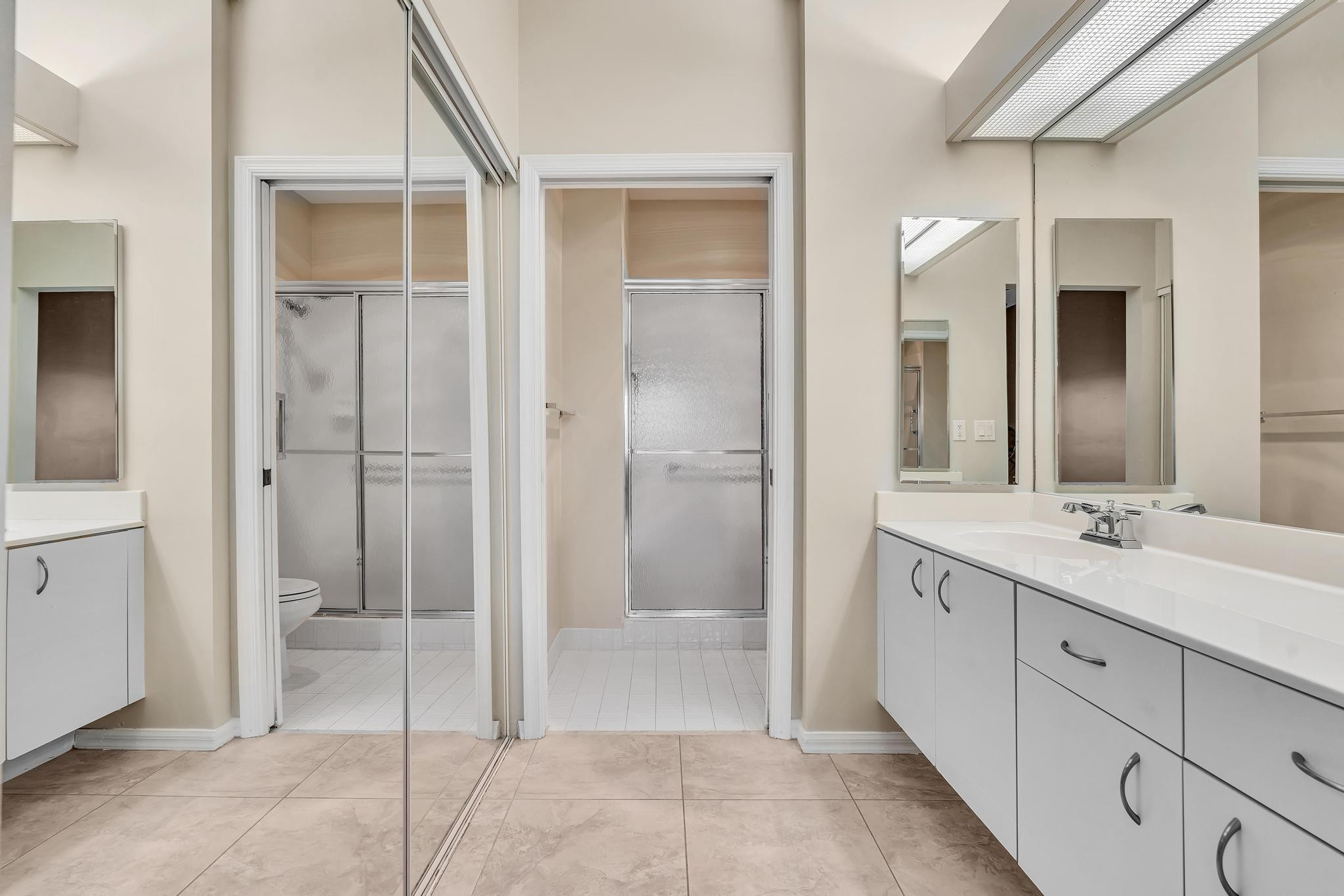 9551 Weldon Circle, Unit E411 Tamarac, FL 33321 - Photo 24 of 78 a bathroom with a double vanity sink and a mirror