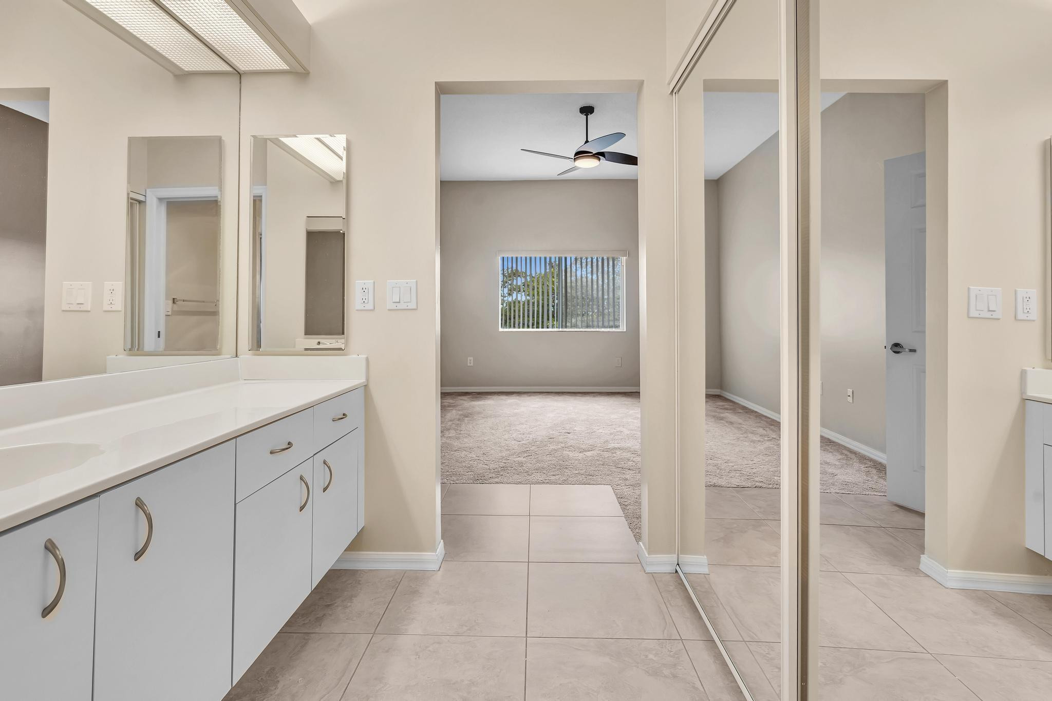 9551 Weldon Circle, Unit E411 Tamarac, FL 33321 - Photo 25 of 78 a bathroom with a sink a mirror and a shower