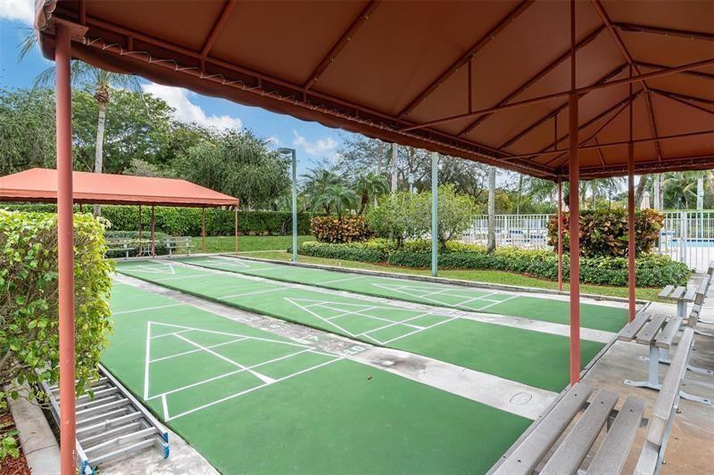 9551 Weldon Circle, Unit E411 Tamarac, FL 33321 - Photo 50 of 78 a view of a backyard with a small yard and deck