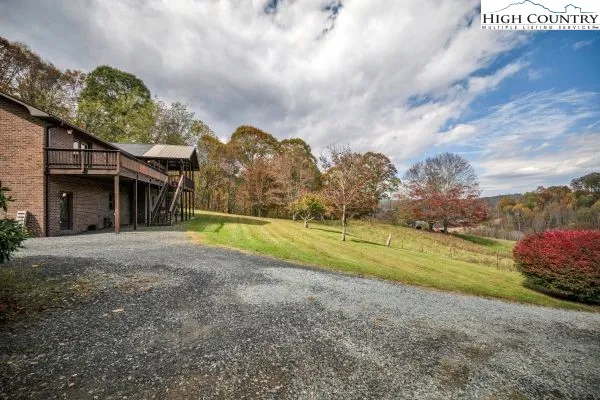 a view of a house with a big yard and a large tree