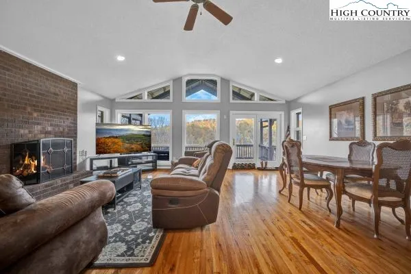 a living room with furniture a fireplace a flat screen tv and wooden floor