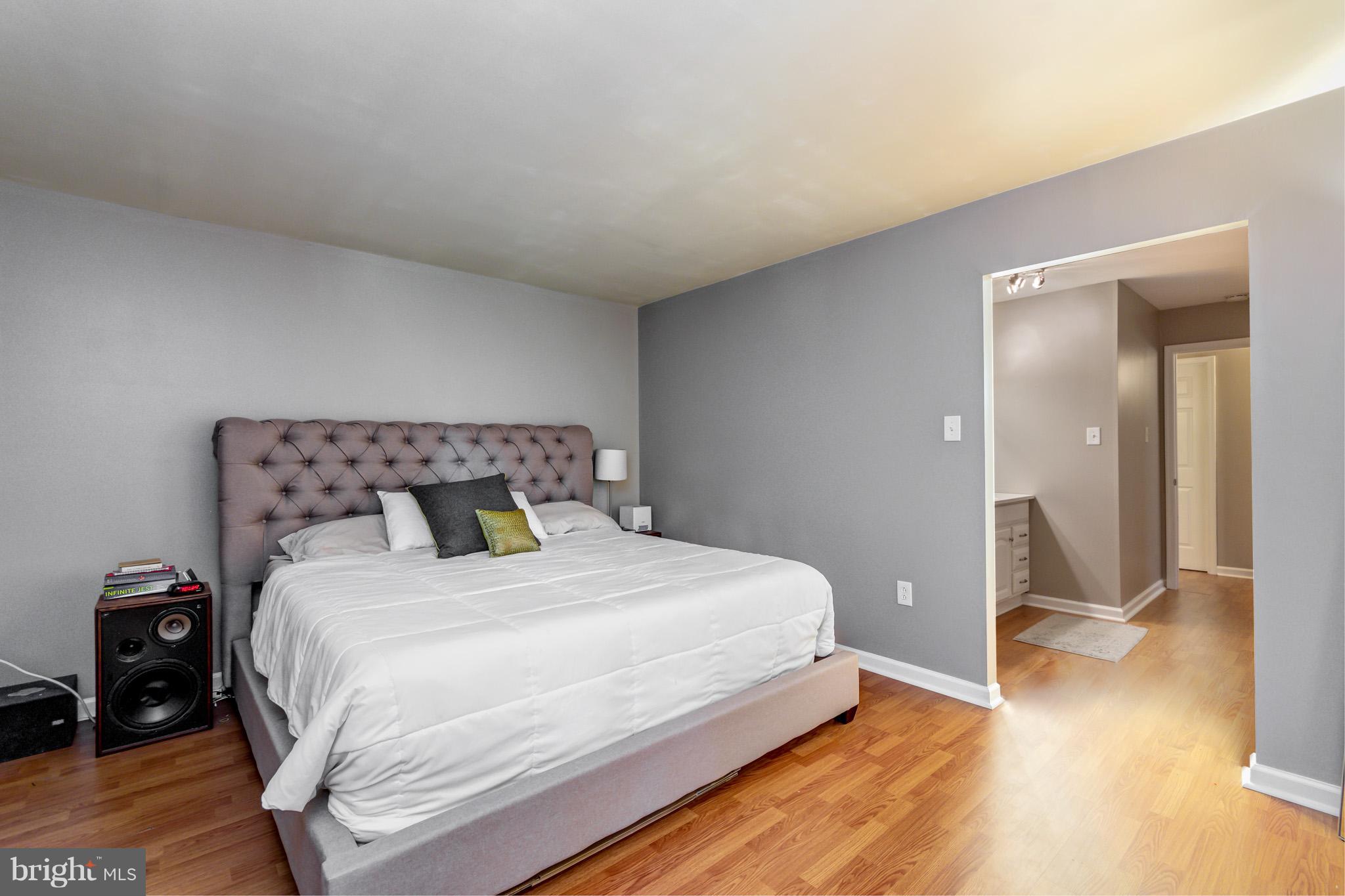 5236 West Running Brook Road, Unit 302 Columbia, MD 21044 - Photo 13 of 25 a bedroom with a bed and wooden floor