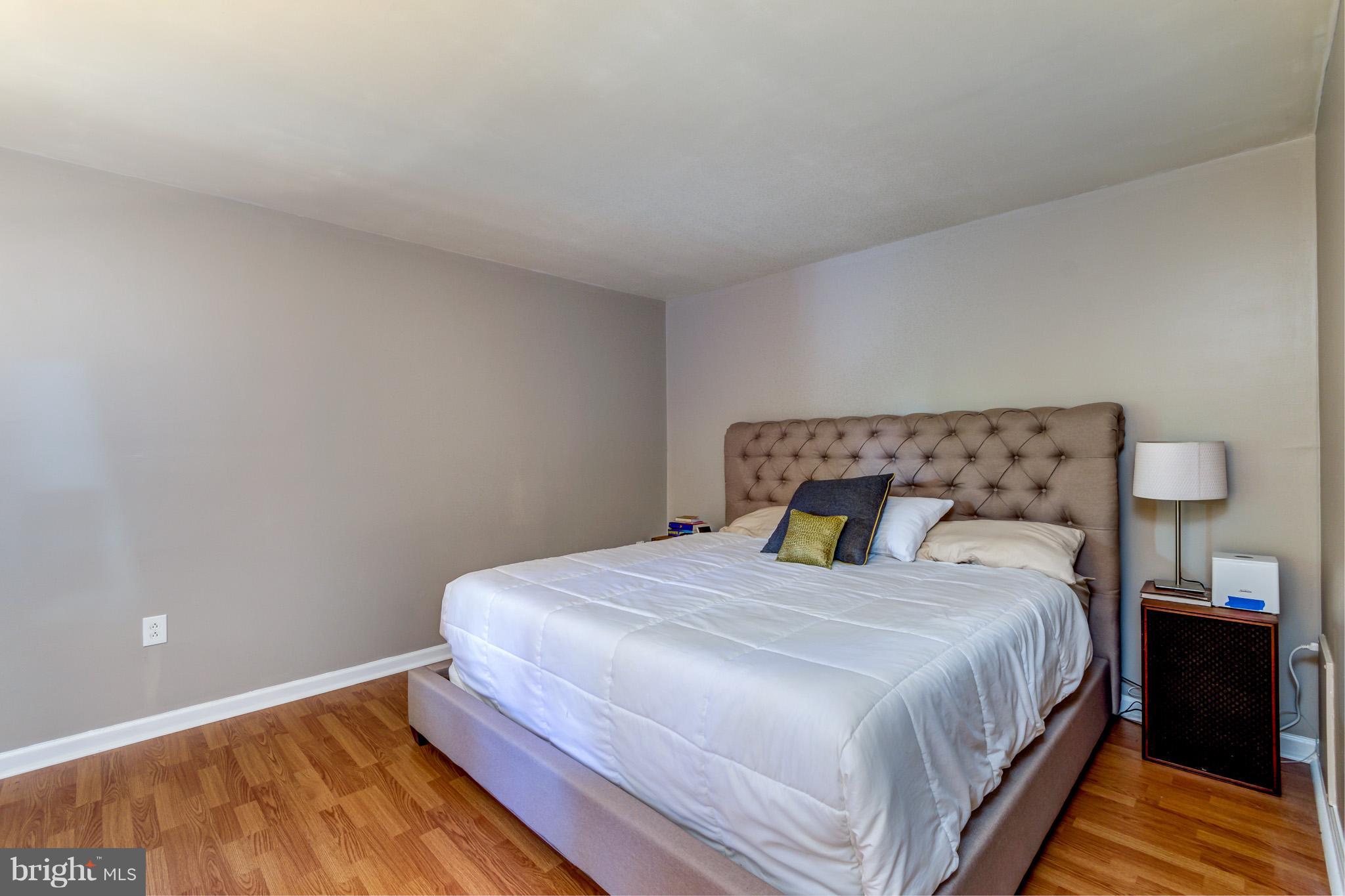 5236 West Running Brook Road, Unit 302 Columbia, MD 21044 - Photo 14 of 25 a bedroom with a bed and wooden floor