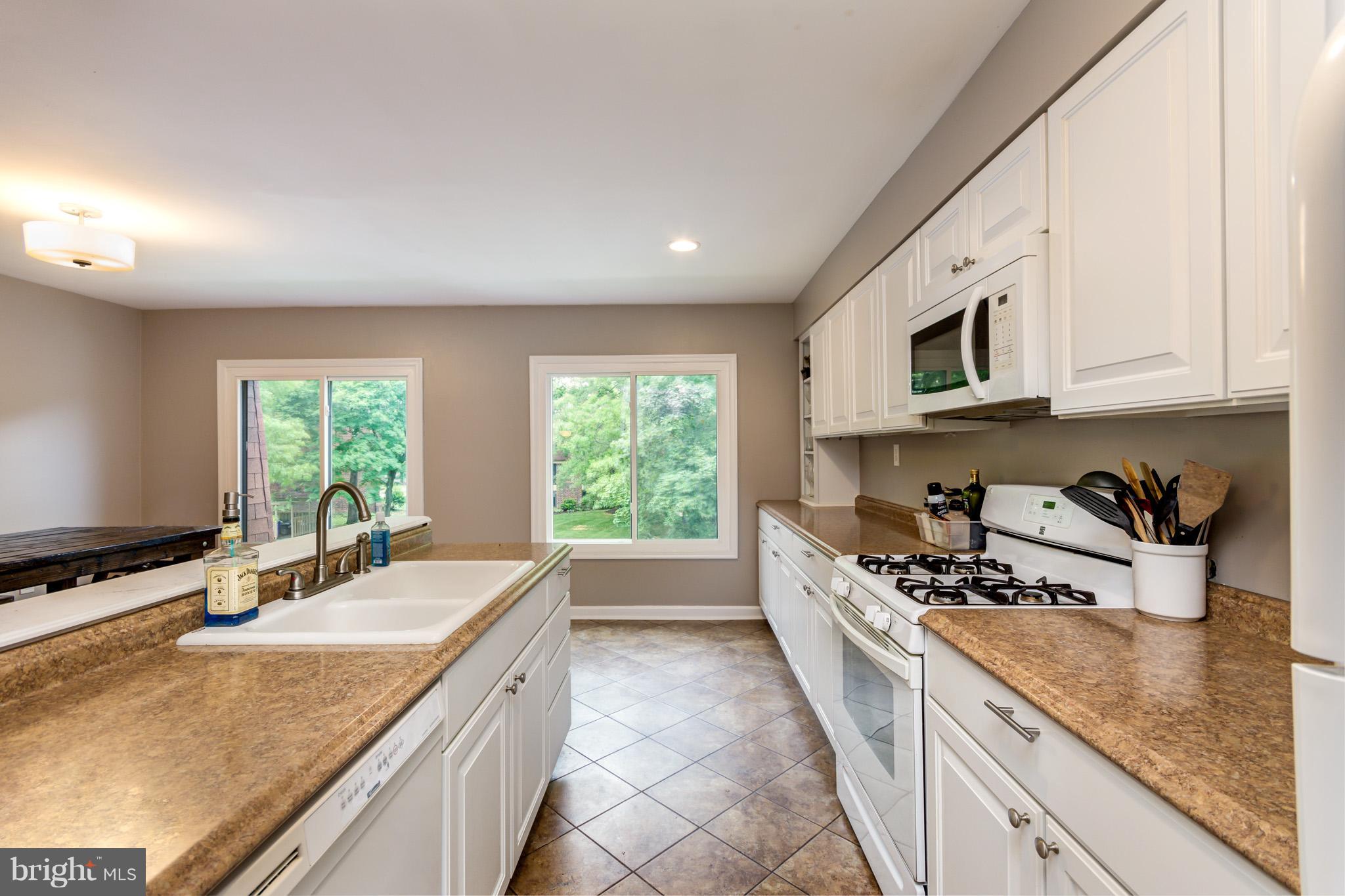 5236 West Running Brook Road, Unit 302 Columbia, MD 21044 - Photo 7 of 25 a kitchen with a sink stove top oven and microwave
