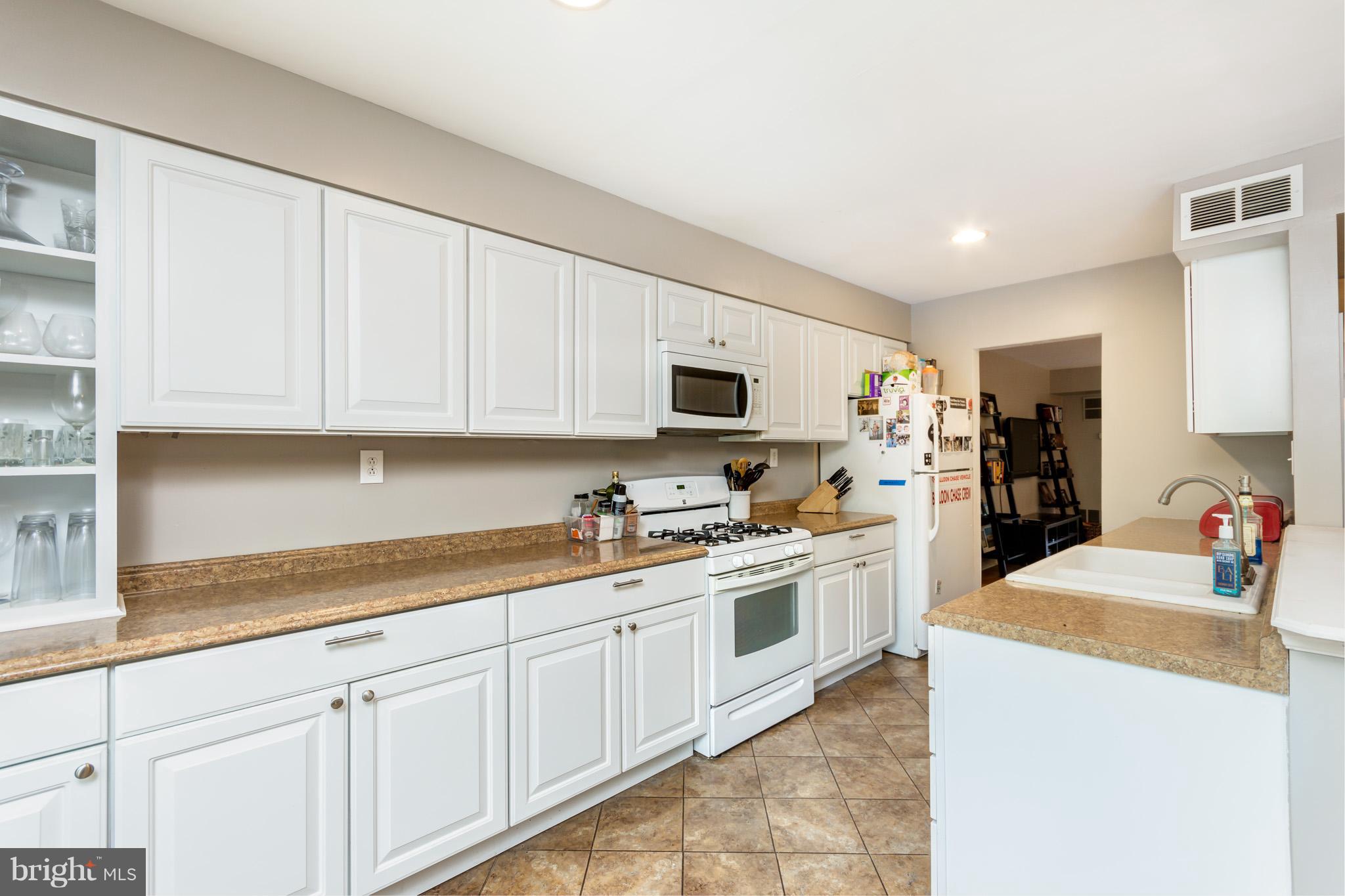 5236 West Running Brook Road, Unit 302 Columbia, MD 21044 - Photo 8 of 25 a kitchen with granite countertop white cabinets and white appliances