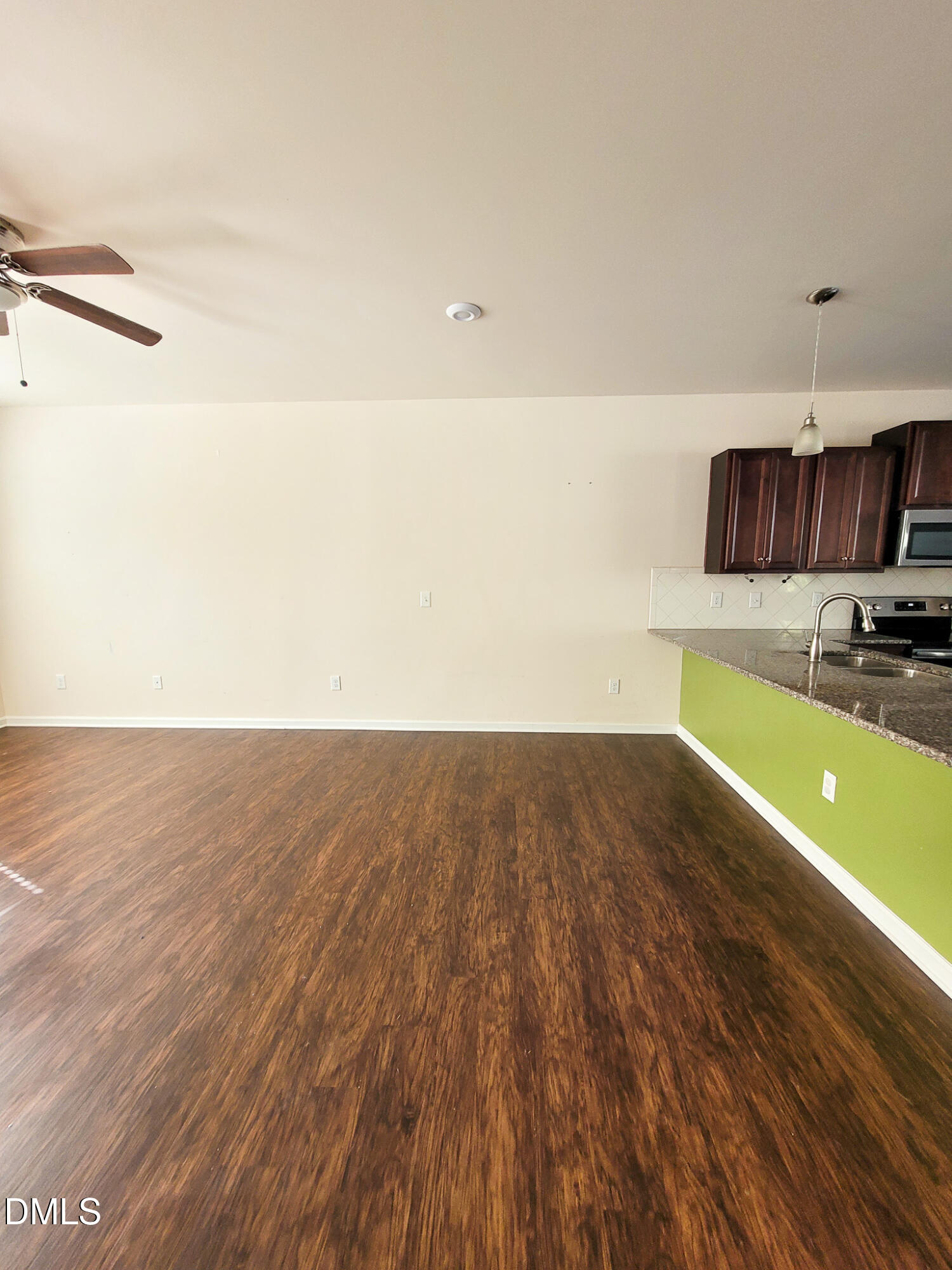 8951 Commons Townes Drive Raleigh, NC 27616 - Photo 10 of 40 a view of kitchen and empty room with wooden floor