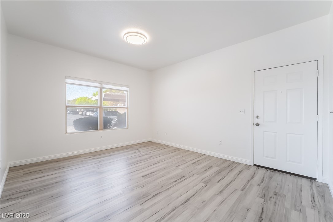Unfurnished room featuring light wood-type flooring and baseboards