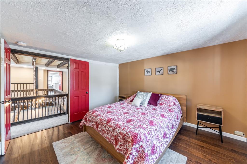 369 Mill Dam Road Cheswick, PA 15024 - Photo 16 of 25 a bedroom with a bed a dresser and wooden floor