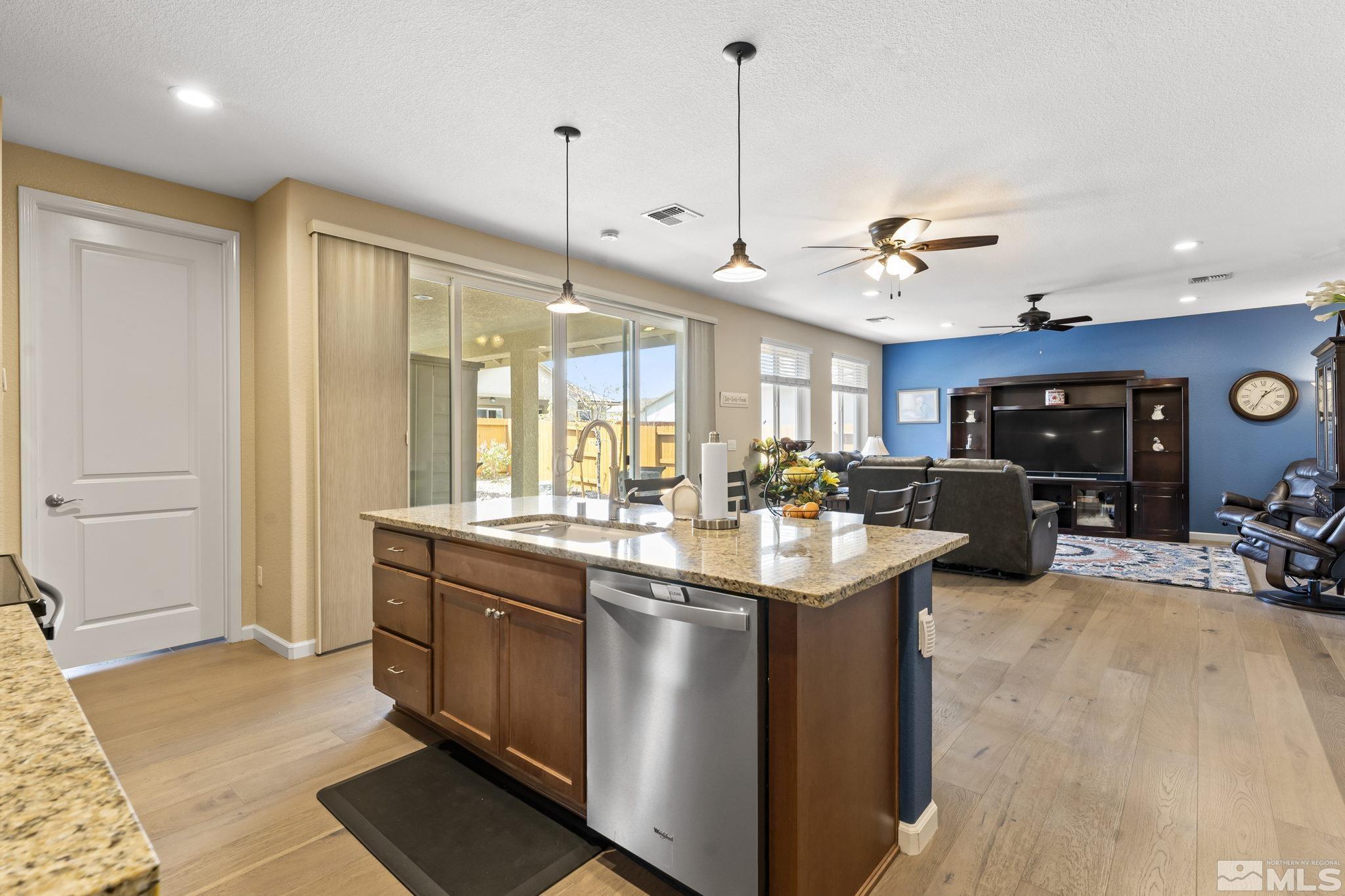 9593 Gazala Lane Reno, NV 89521 - Photo 8 of 37 a kitchen with kitchen island a sink and a stove with wooden floor