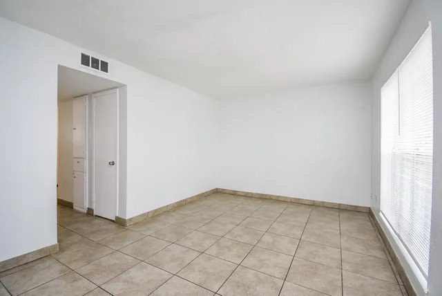 an empty room with white walls and tiles