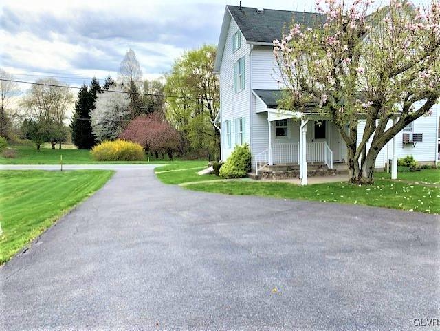 A tarred driveway and a covered back porch.