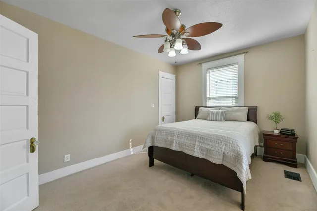 a bedroom with a bed and a ceiling fan