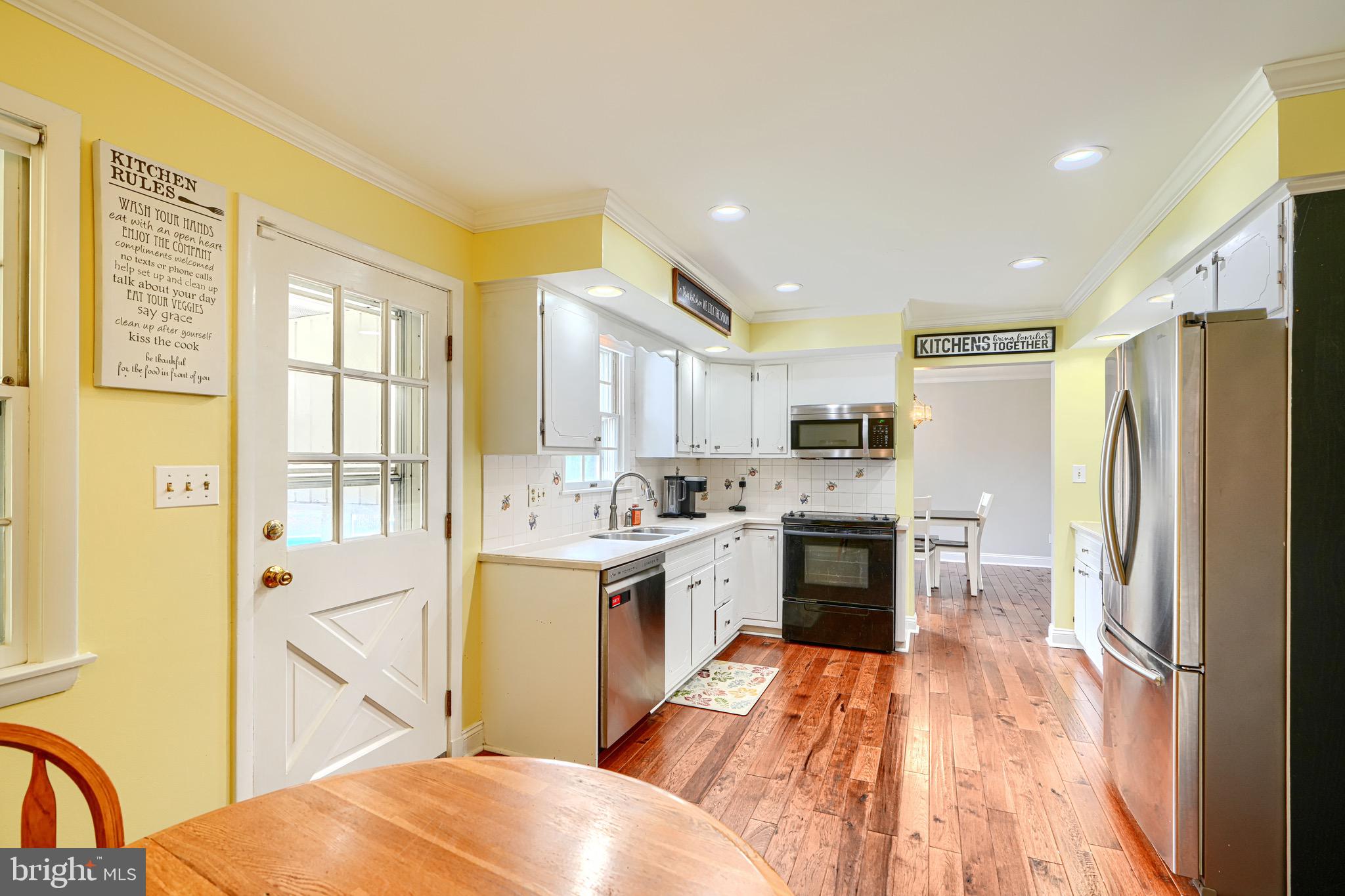 4225 Chapel Road Perry Hall, MD 21128 - Photo 20 of 65 a open kitchen with a refrigerator a stove top oven a sink and a dining table with wooden floor