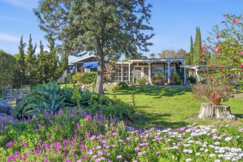 a front view of a house with a yard and fountain in middle of the house