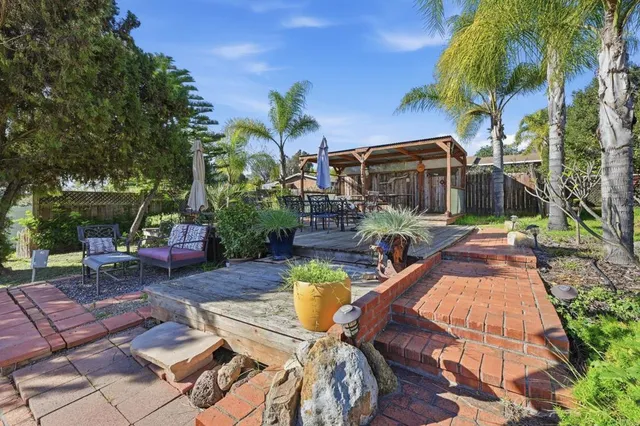 a view of a dinning table and chairs in patio of the house