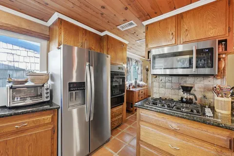 a kitchen with stainless steel appliances granite countertop a refrigerator and a stove