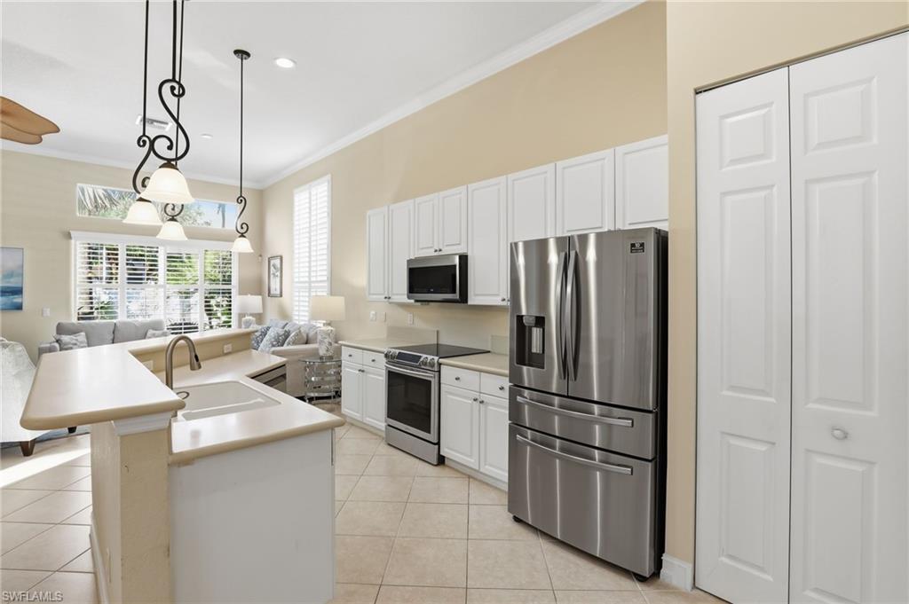 1769 Sanctuary Pointe Court Naples, FL 34110 - Photo 11 of 40 a kitchen with stainless steel appliances granite countertop a refrigerator a stove a sink and a refrigerator