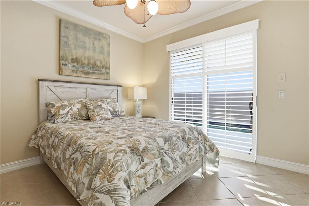 1769 Sanctuary Pointe Court Naples, FL 34110 - Photo 20 of 40 a large bed sitting in a bedroom next to a window and a chandelier