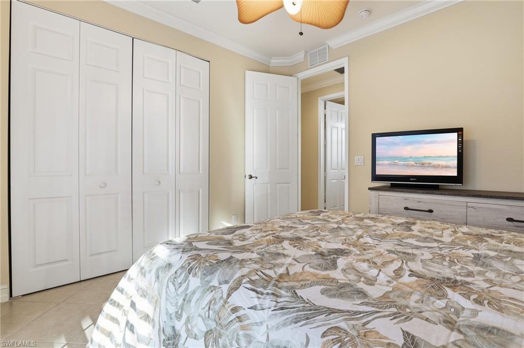 1769 Sanctuary Pointe Court Naples, FL 34110 - Photo 21 of 40 a bedroom with a bed and a flat screen tv