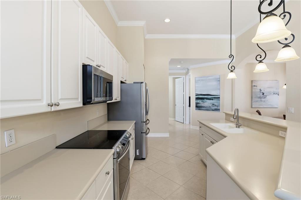 1769 Sanctuary Pointe Court Naples, FL 34110 - Photo 8 of 40 a kitchen that has a microwave a sink and a stove in it