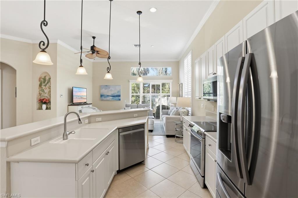 1769 Sanctuary Pointe Court Naples, FL 34110 - Photo 10 of 40 a kitchen with stainless steel appliances a refrigerator a sink a oven and a sink